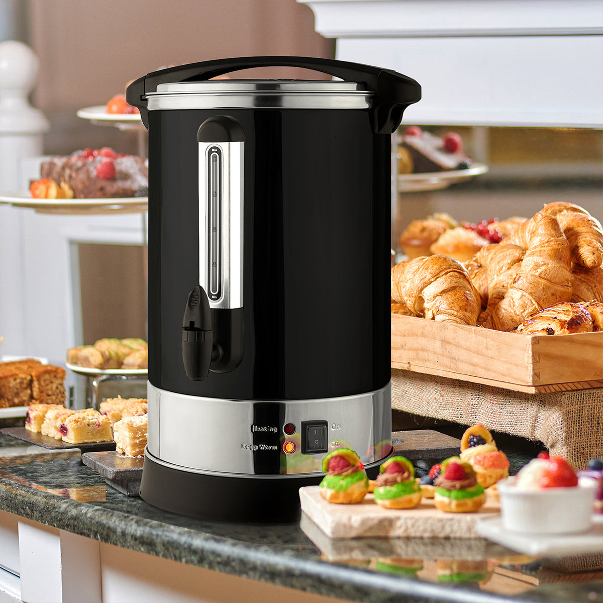 Black and silver hot Zulay Kitchen coffee urn on a kitchen counter with pastries in the background