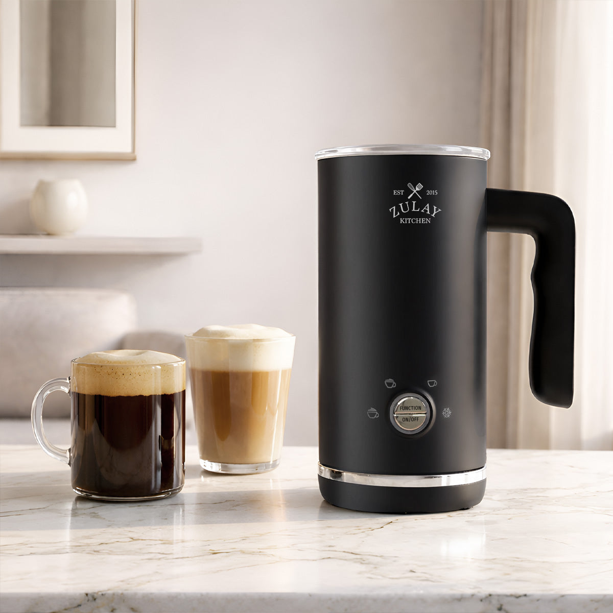 Black milk frother with two coffee drinks on a marble countertop