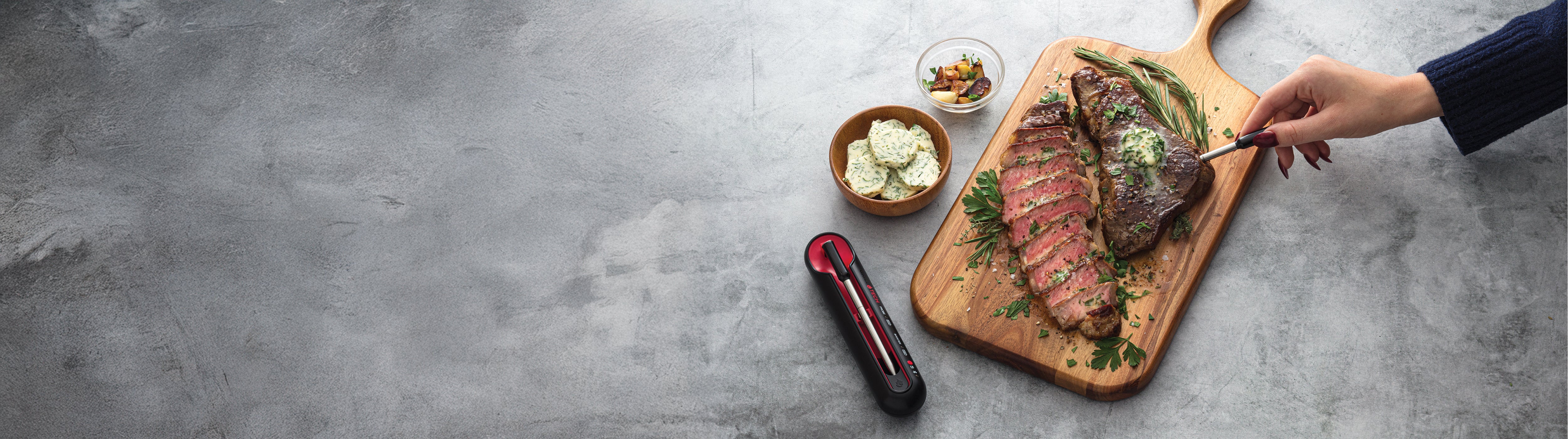 Steak on a cutting board with Grill Tech thermometer.