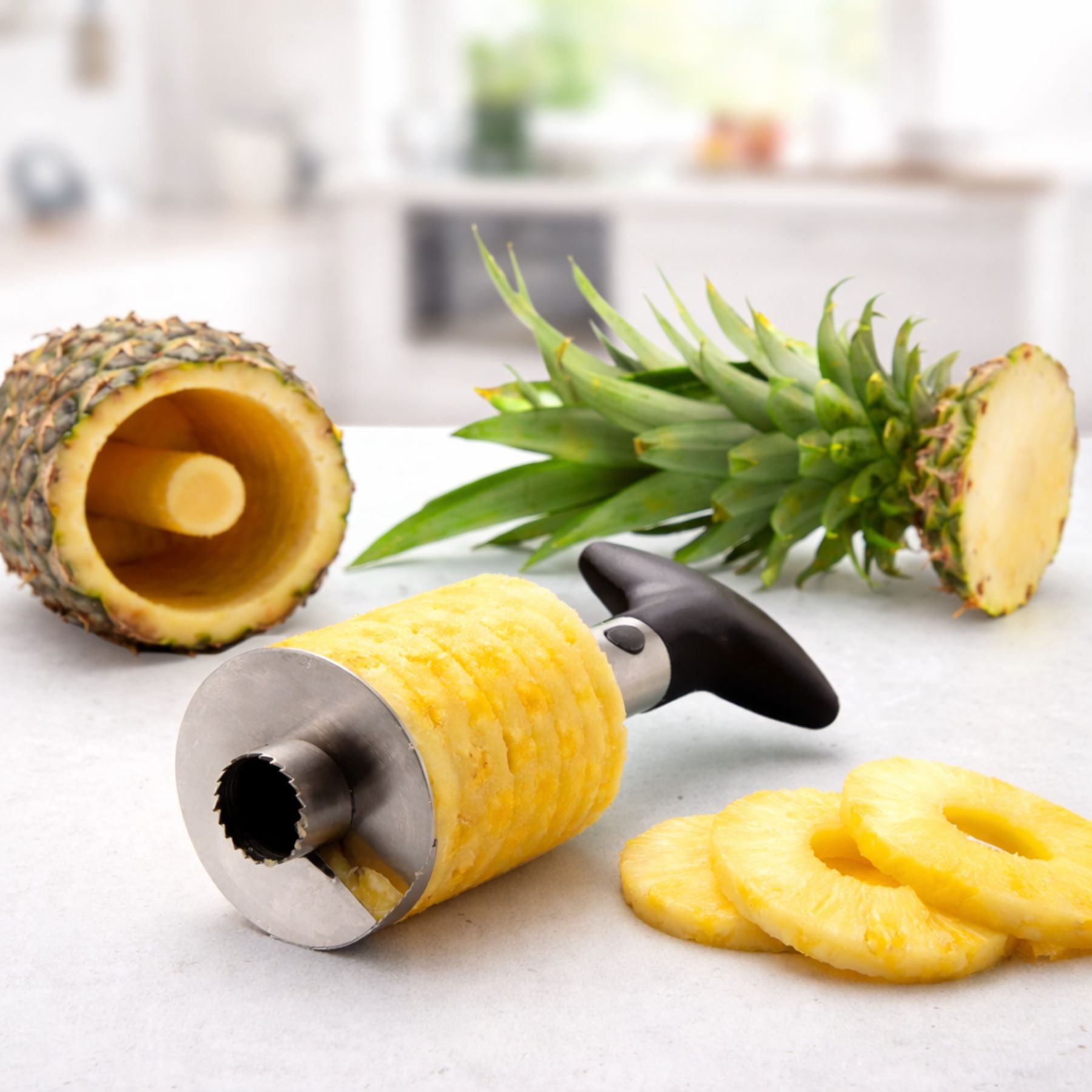 Pineapple slicer with sliced pineapple on a kitchen counter