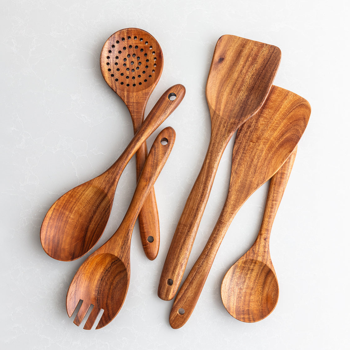 Set of wooden cooking utensils on a light gray background