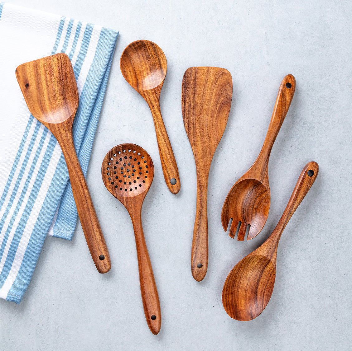 Set of wooden cooking utensils on a light gray background
