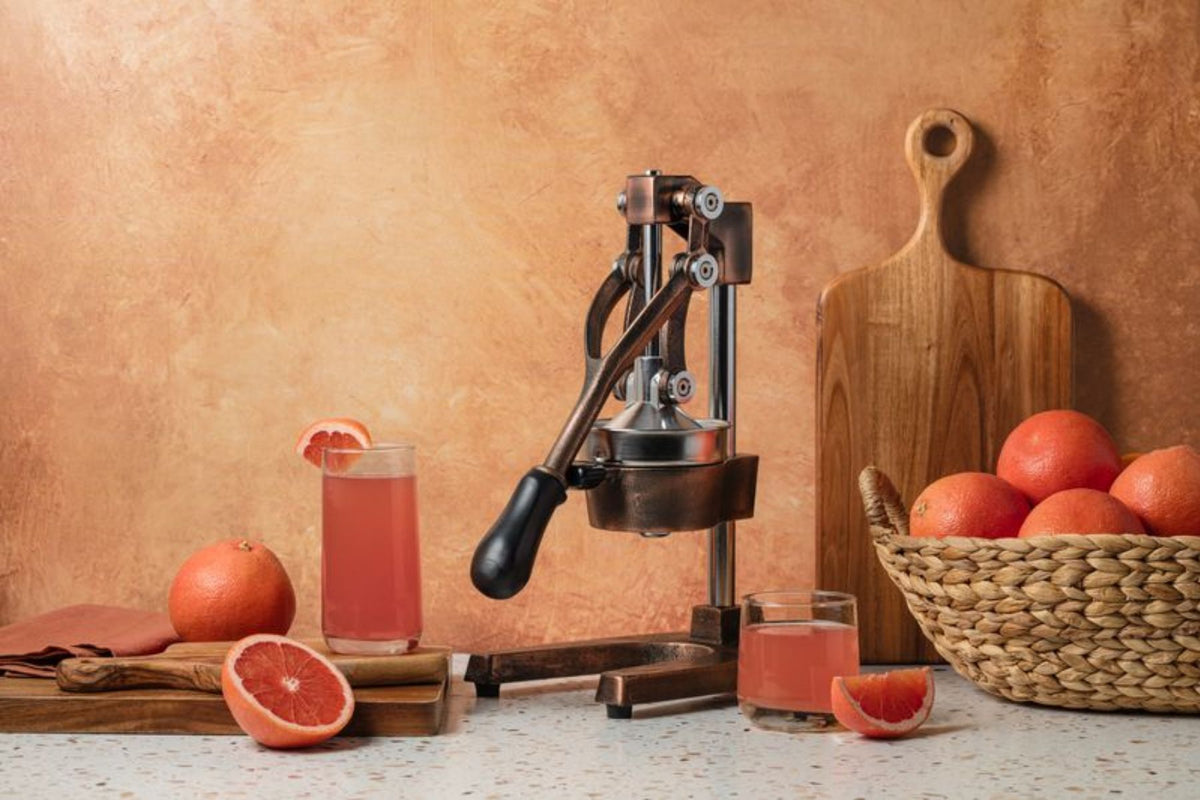 Manual juicer with grapefruits and juice on a rustic background