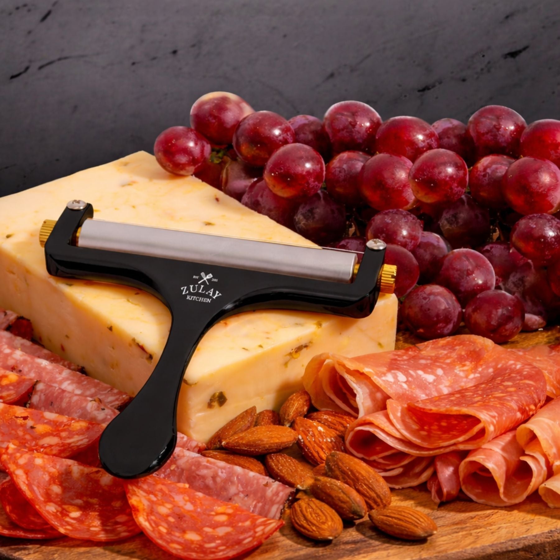 Cheese, salami, grapes, and almonds with the Zulay Kitchen Wire Cheese Slicer on a wooden board.