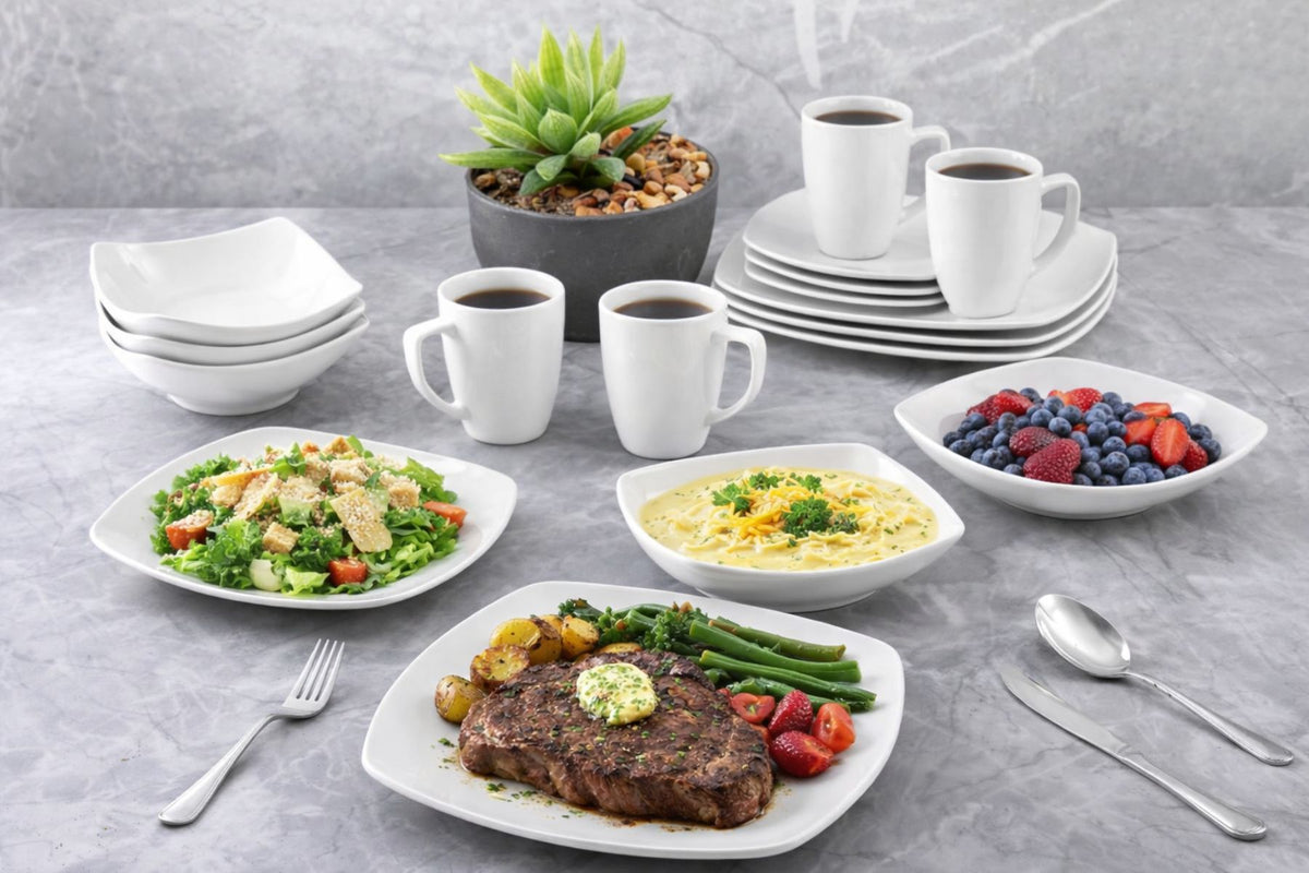 Dinner setting with plates of food, cups, and a small plant on a gray surface.