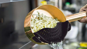 Draining pasta using Zulay kitchen Adjustable Silicone Pot Strainer.