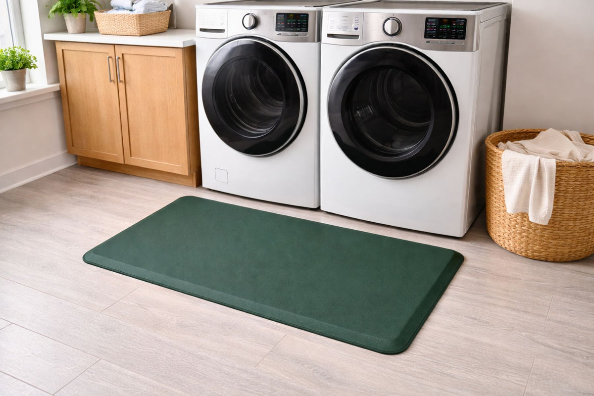 Green mat in front of a washer and dryer in a laundry room.