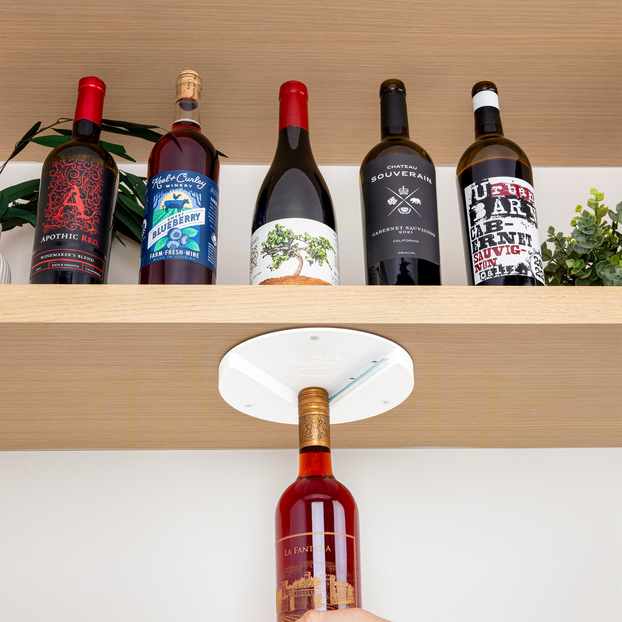 Collection of wine bottles on a wooden shelf with EZ Off Under Cabinet Jar Opener 
