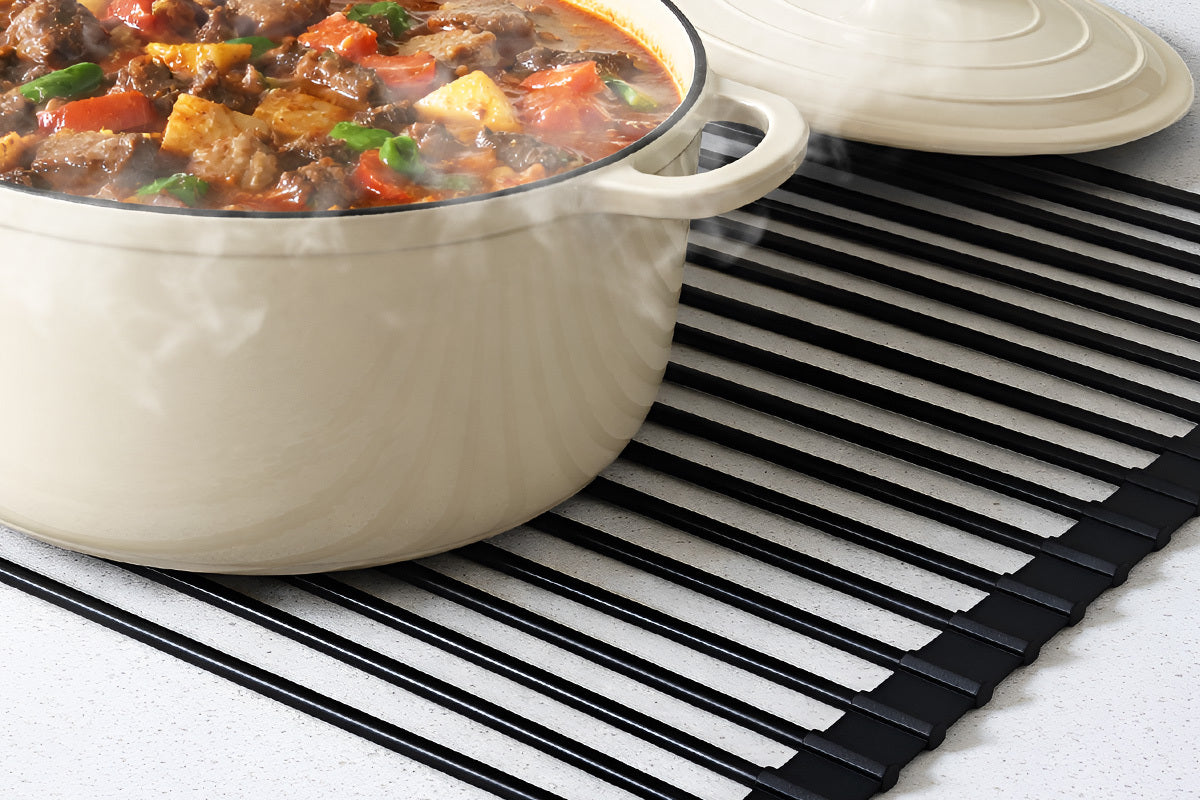 Beige pot with stew on a black mat