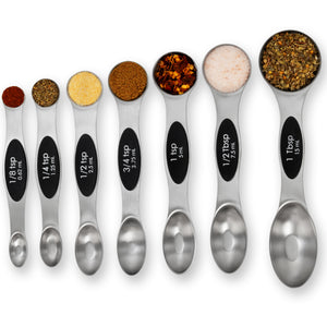 Set of metal measuring spoons with spices on a white background