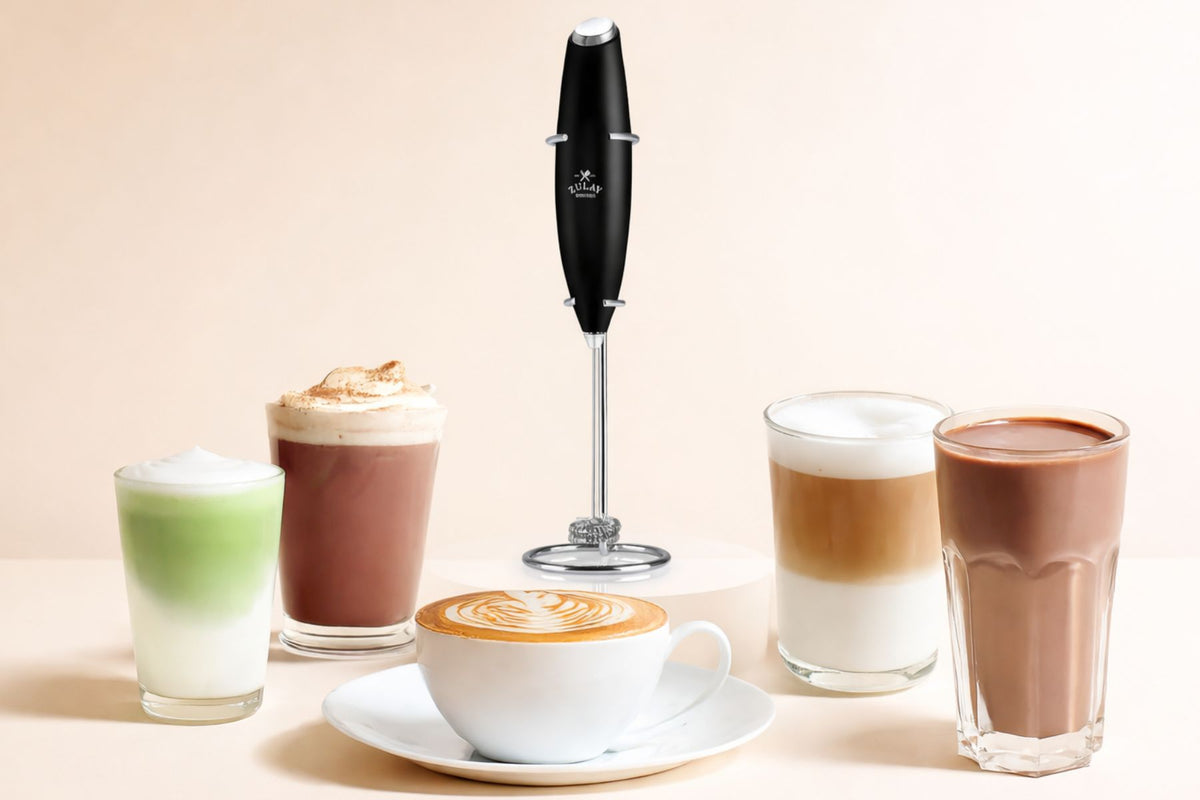 Collection of coffee drinks and a milk frother on a beige background
