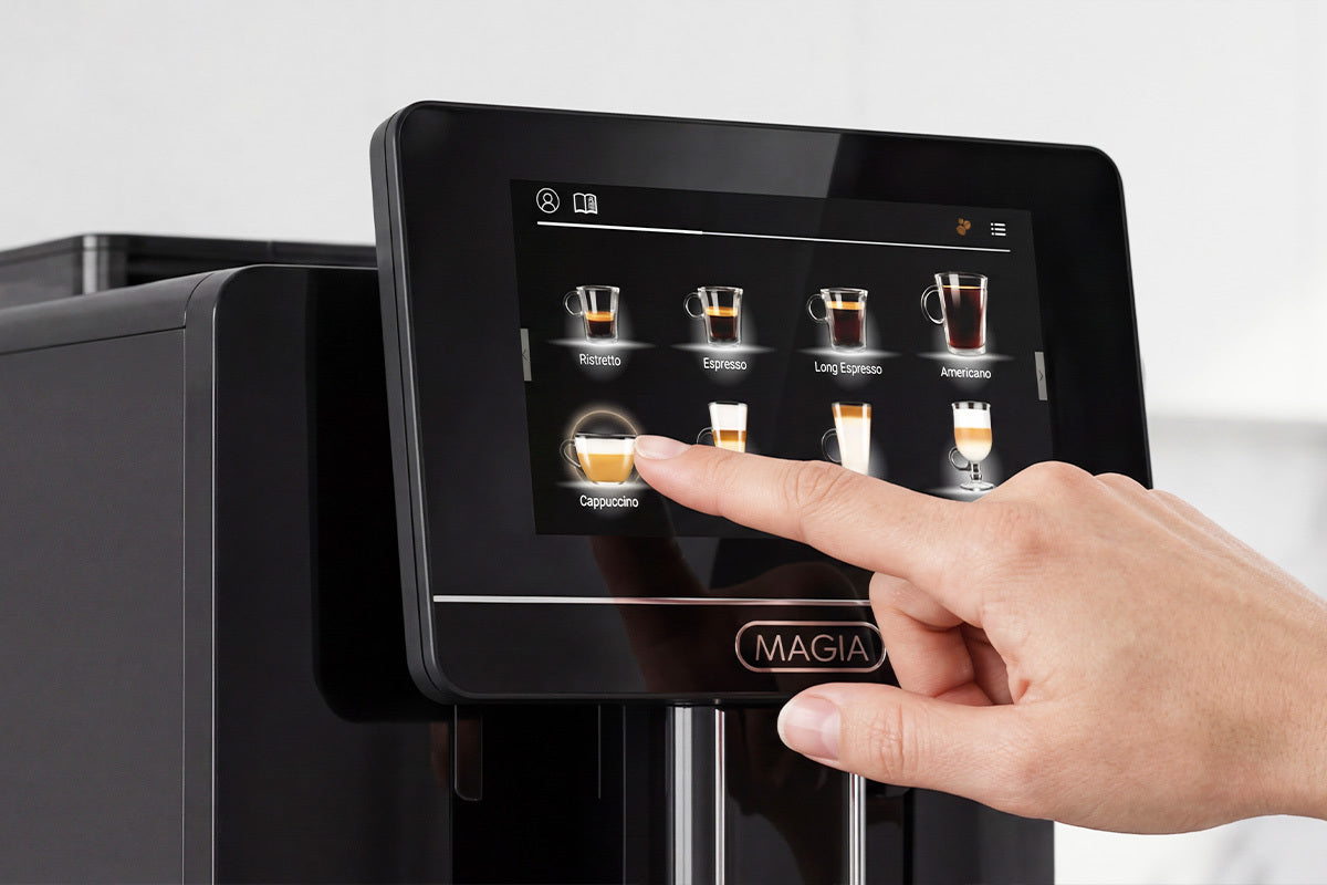 Hand interacting with a Zulay Magia Super Automatic Espresso Machine's touch screen display labeled 'MAGIA'.