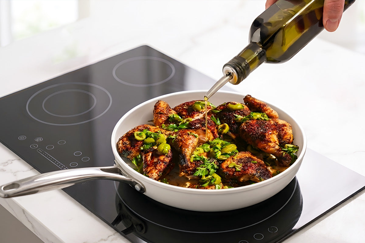 Person pouring oil into a pan of food on a stovetop