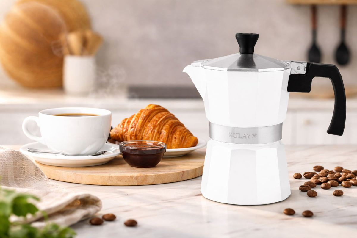 Premium Moka Pot Espresso Maker on a kitchen counter with coffee cup, croissant, and coffee beans.
