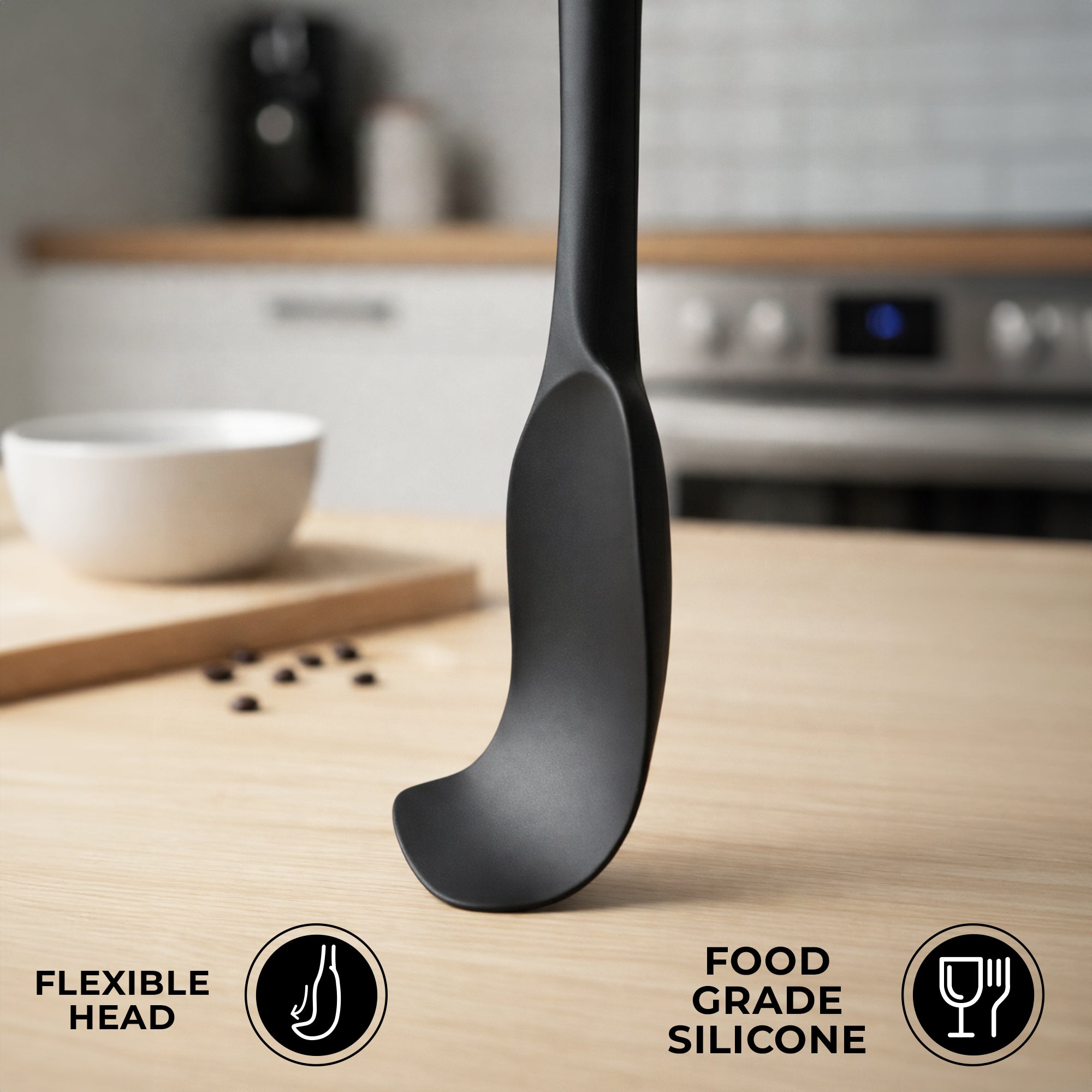 Black Zulay Kitchen silicone spatula on a kitchen counter with icons indicating 'flexible head' and 'food grade silicone'.