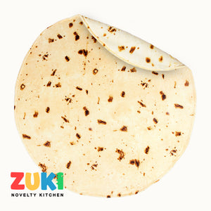 Round flatbread blanket with ZUKI Novelty Kitchen logo on a white background