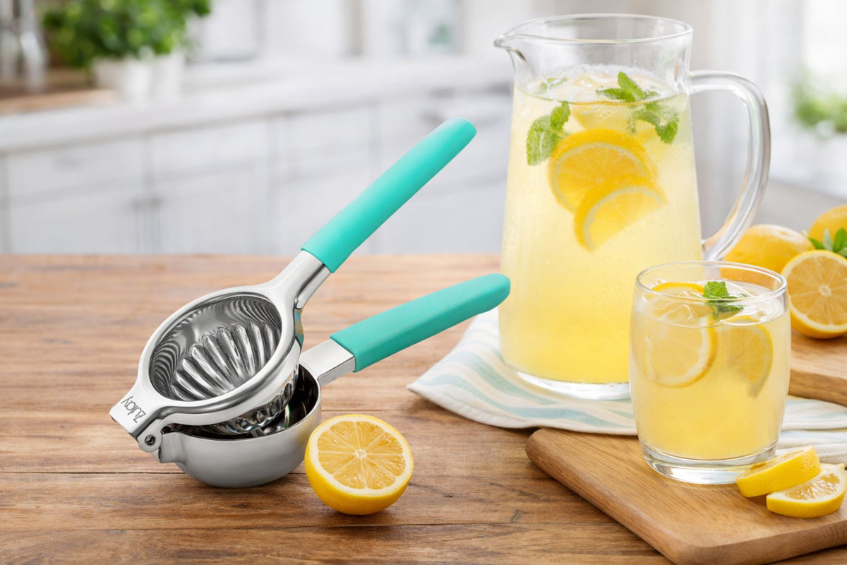 Zulay Kitchen Stainless Steel Lemon Squeezer with a glass of lemonade and pitcher on a wooden table.