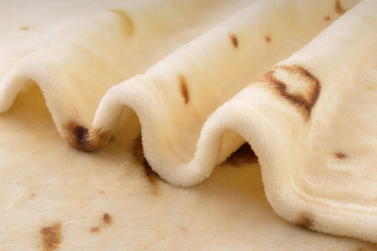 Close-up of a folded piece Zulay Kitchen tortilla blanket with brown spots