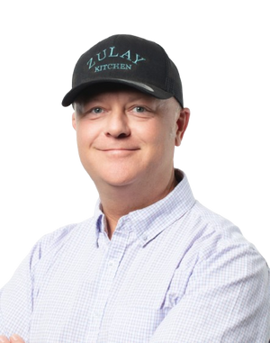 Stephen wearing a black cap with 'Zulay Kitchen' logo on a white background
